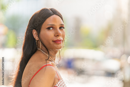 Transgender woman turning to look at the camera outdoors