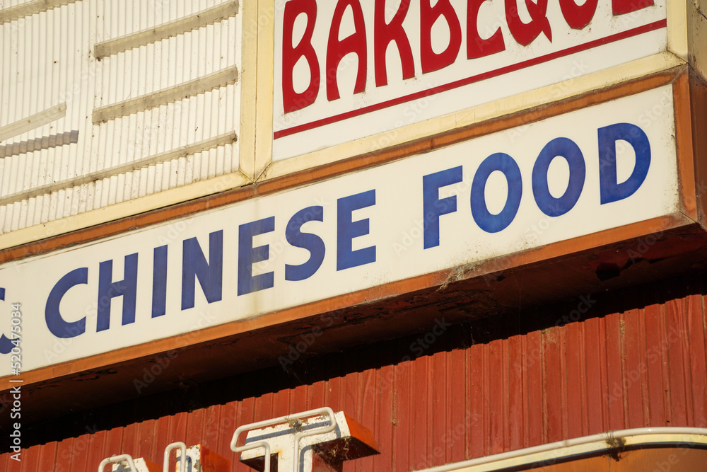 Old worn Chinese food sign on building