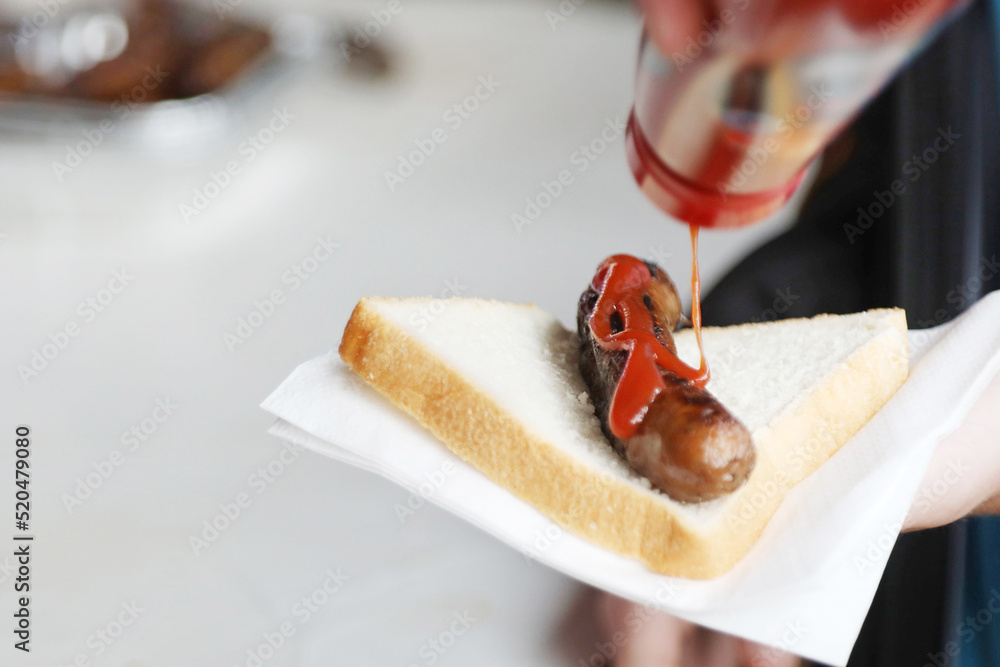 The humbe sausage sandwich or sausage in bread. Sang sanga. Traditional  kids favorite at the bbq fundraiser with white bread and bright red tomato  sauce or ketchup Stock 写真 | Adobe Stock