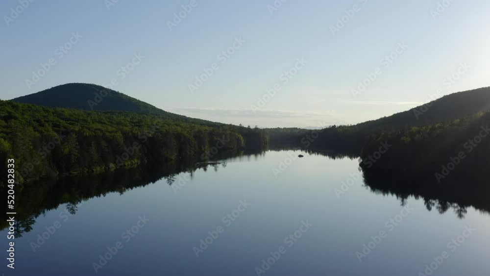 Low fly over the mountain lake. Aerial of a mountain lake surrounded by green forest. Vermont. Low fly over the mountain lake. Aerial of a mountain lake surrounded by green forest. Vermont.