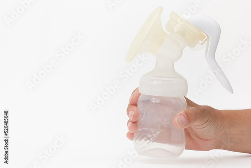 Isolated baby empty manual breast pump in cropped woman hand on white background with copy space photo