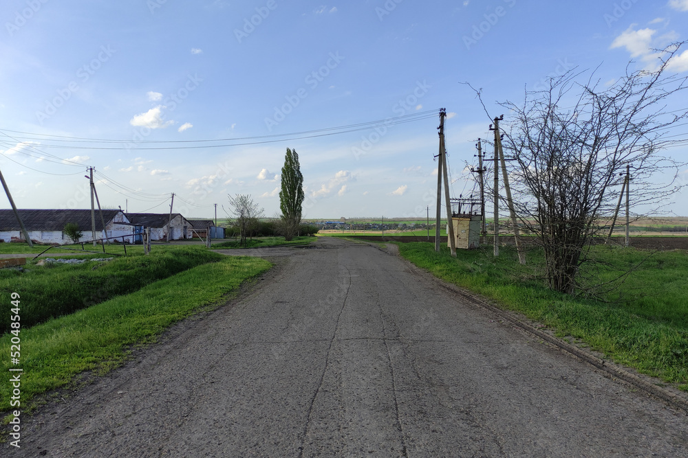 Asphalt road in the countryside and electrical lines in summer Asphalt road in the countryside and electrical lines in summer
