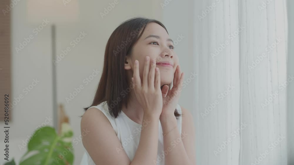 Beautiful girl with hydrated facial skin. Portrait of smiling Asian girl with natural makeup and healthy smooth skin looking at camera. 