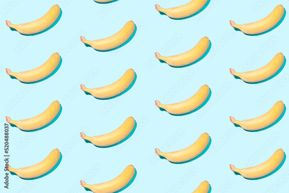 Yellow bananas on a light mint background in even rows