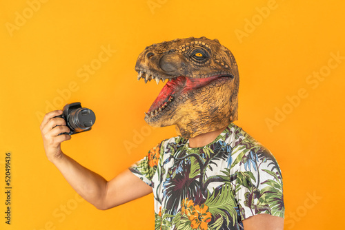 Man using professional camera wearing animal head mask isolated on yellow background.Photographer studio concept.