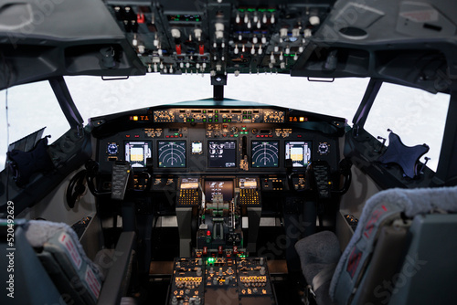 No people in empty captain cabin with dashboard navigation and engine throttle to fly airplane and travel. Cockpit with control panel command and power buttons, radar compass and windscreen.