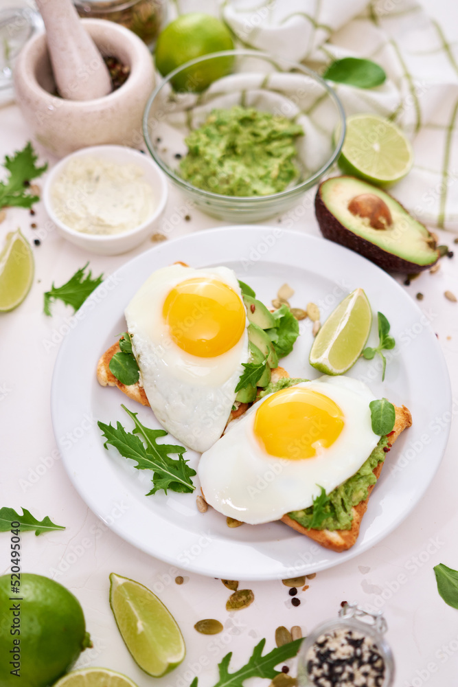 healthy breakfast or snack - sliced avocado and fried egg on toasted bread healthy breakfast or snack - sliced avocado and fried egg on toasted bread