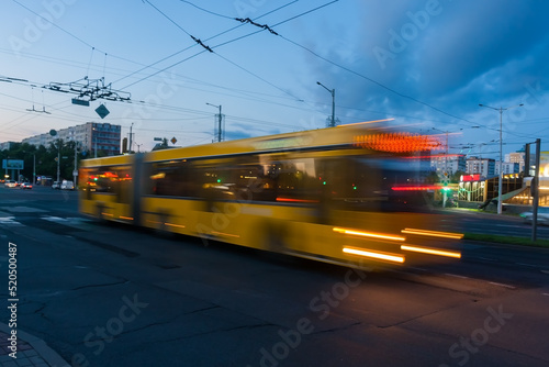 Blurred bus movement along the avenue in the evening.