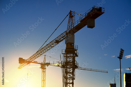 Silhouette of modern construction site during summer sunset