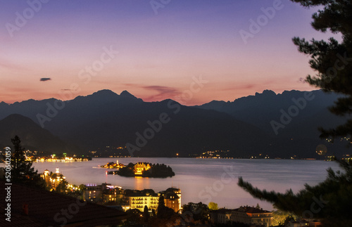 Lake Maggiore at sunset, fiery sky and lights on the coast and islands.Stresa, Italy