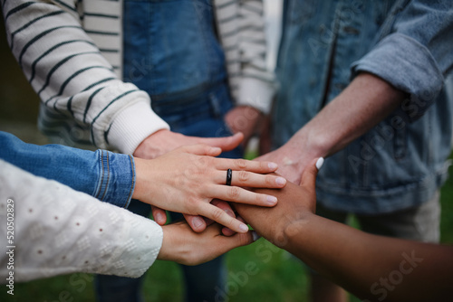 Close-up of diverse group of friends stacking their hands together in circle, Friendship and lifestyle concepts
