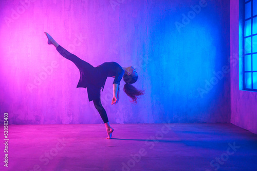 Принти на полотні Modern dance girl dancer dancing in neon light doing gymnastic exercises in studio, copy space