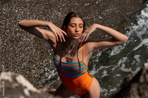 Artistic portrait of a pretty Caucasian woman in swimwear sunbathing on the beach