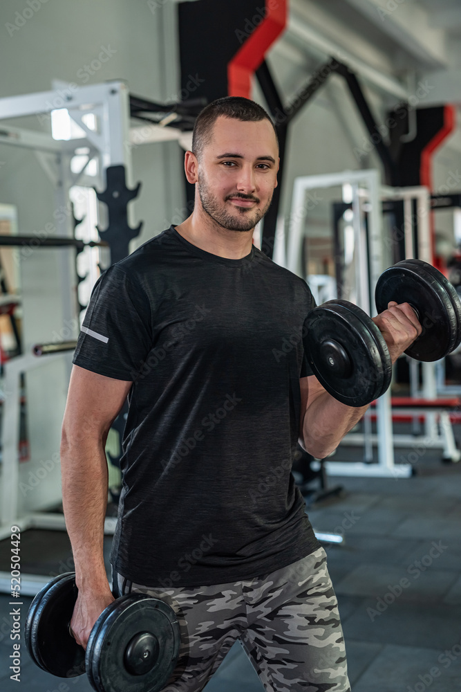 caucasian man doing workout with dumbbells in gym caucasian man doing workout with dumbbells in gym