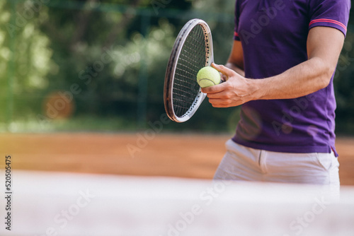 Young man tennis player at the court, tennis racket close up © Petro