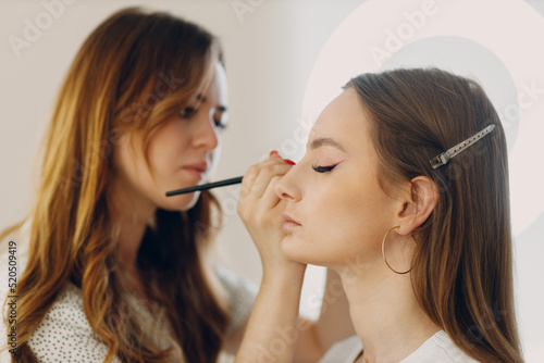Beautiful young woman applying makeup beauty visage brush.
