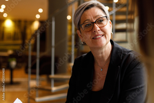 Mature businesswoman listening in meeting at office