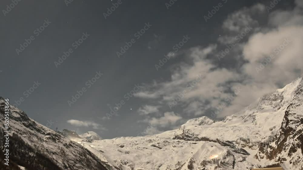 Timelapse during a sunrise, clouds pass over the snowy mountains of saas fee during the winter Timelapse during a sunrise, clouds pass over the snowy mountains of saas fee during the winter