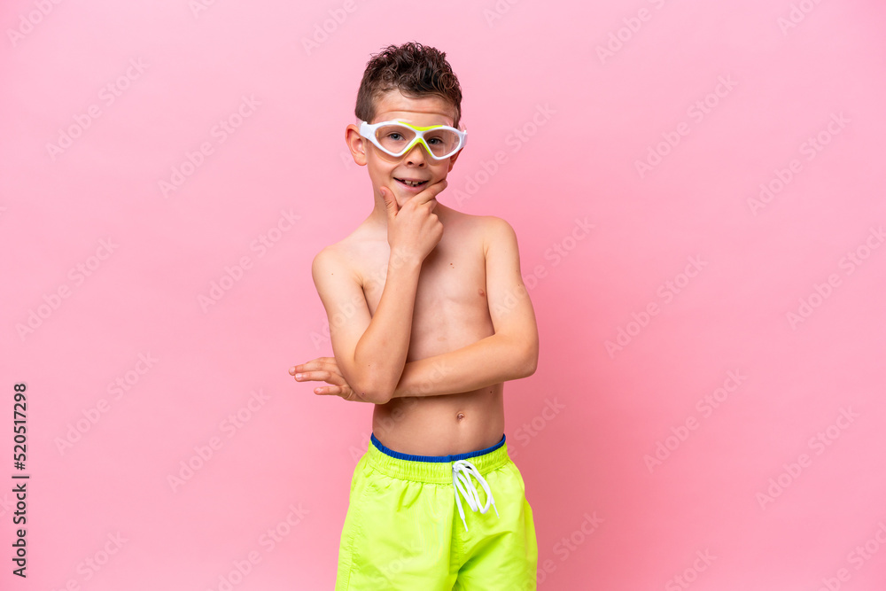 Little caucasian boy wearing a diving goggles isolated on pink background happy and smiling Little caucasian boy wearing a diving goggles isolated on pink background happy and smiling
