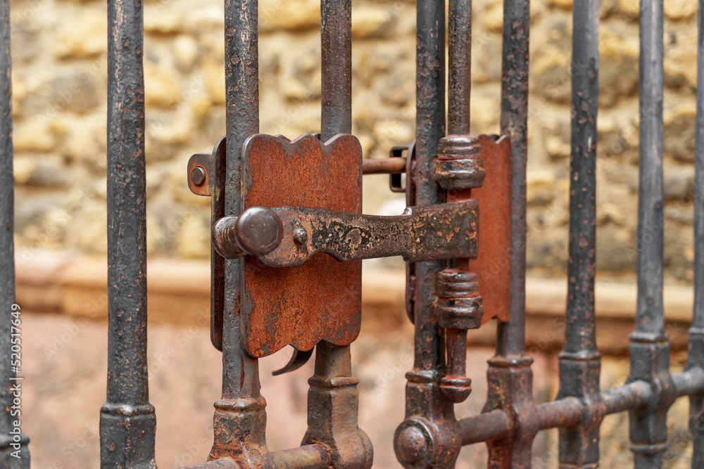 Ancient metal rusty wrought handle deadbolt (latch) of closed door of the lattice gate Ancient metal rusty wrought handle deadbolt (latch) of closed door of the lattice gate