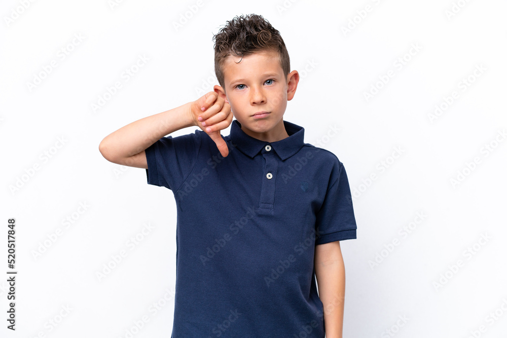 Little caucasian boy isolated on white background showing thumb down with negative expression Little caucasian boy isolated on white background showing thumb down with negative expression