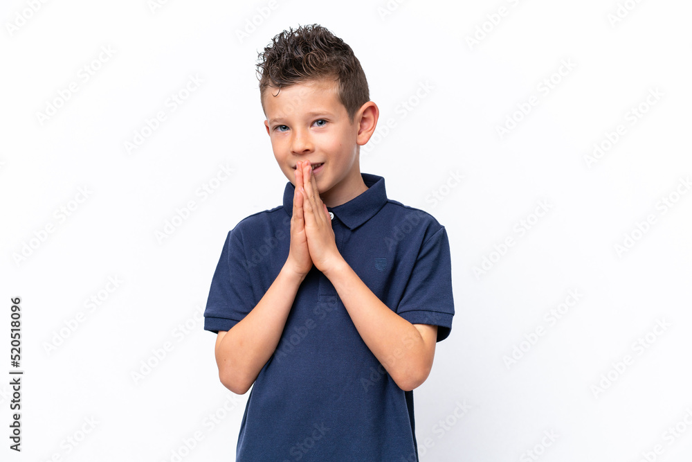 Little caucasian boy isolated on white background keeps palm together. Person asks for something Little caucasian boy isolated on white background keeps palm together. Person asks for something
