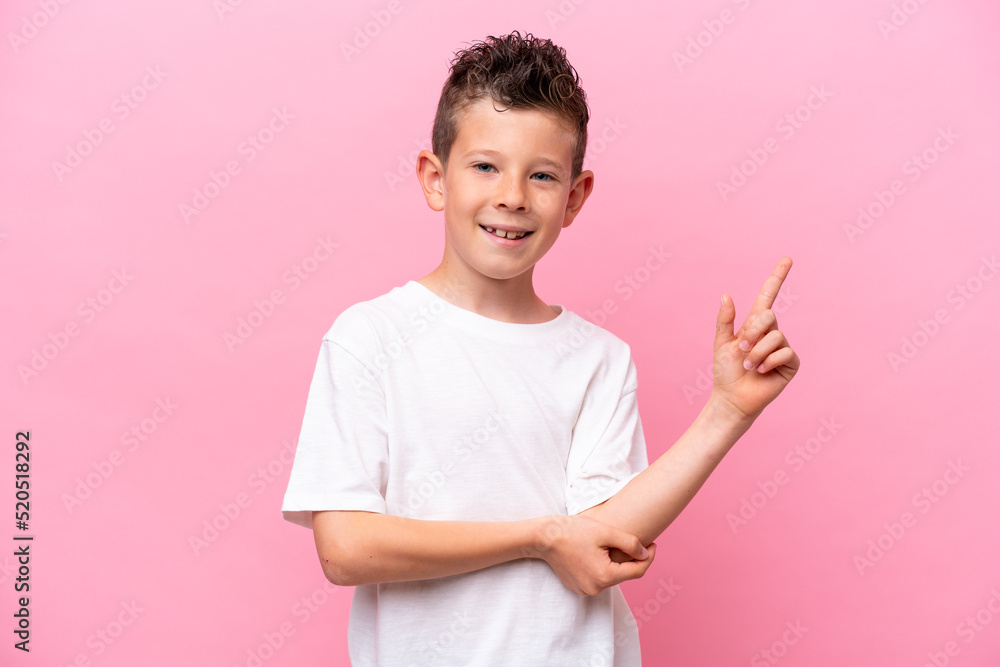 Little caucasian boy isolated on pink background happy and pointing up Little caucasian boy isolated on pink background happy and pointing up