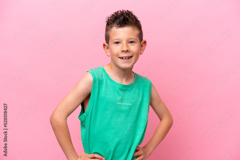 Little caucasian boy isolated on pink background posing with arms at hip and smiling Little caucasian boy isolated on pink background posing with arms at hip and smiling