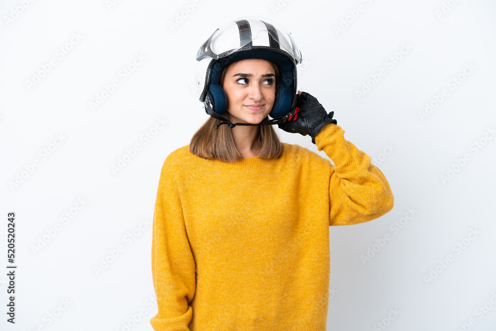 Fototapeta premium Young caucasian woman with a motorcycle helmet isolated on white background having doubts