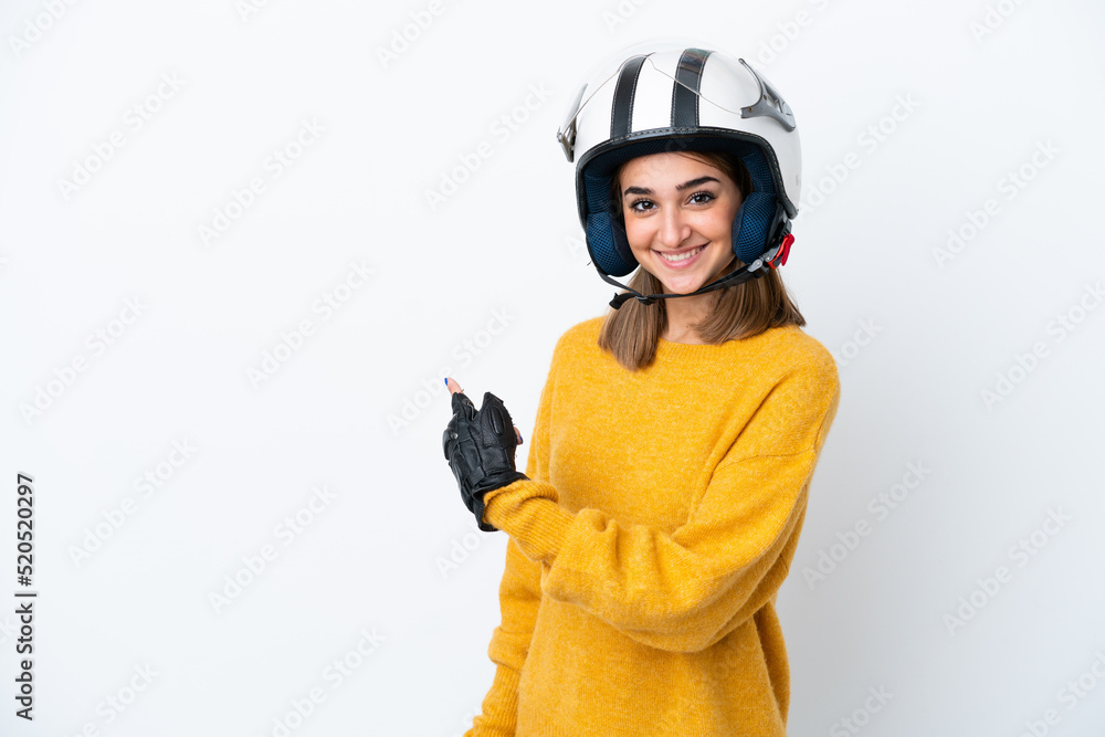 Young caucasian woman with a motorcycle helmet isolated on white background pointing back