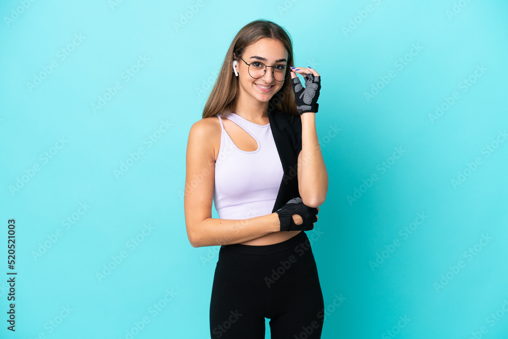 Young sport woman isolated on blue background with glasses and happy Young sport woman isolated on blue background with glasses and happy