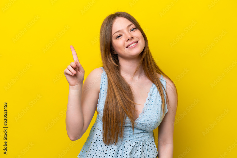Young caucasian woman isolated on yellow background showing and lifting a finger in sign of the best Young caucasian woman isolated on yellow background showing and lifting a finger in sign of the best