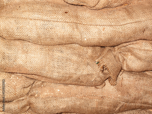 Sandbags background stacked in a heap for use as flood defence or for the military as a barricade, stock photo image