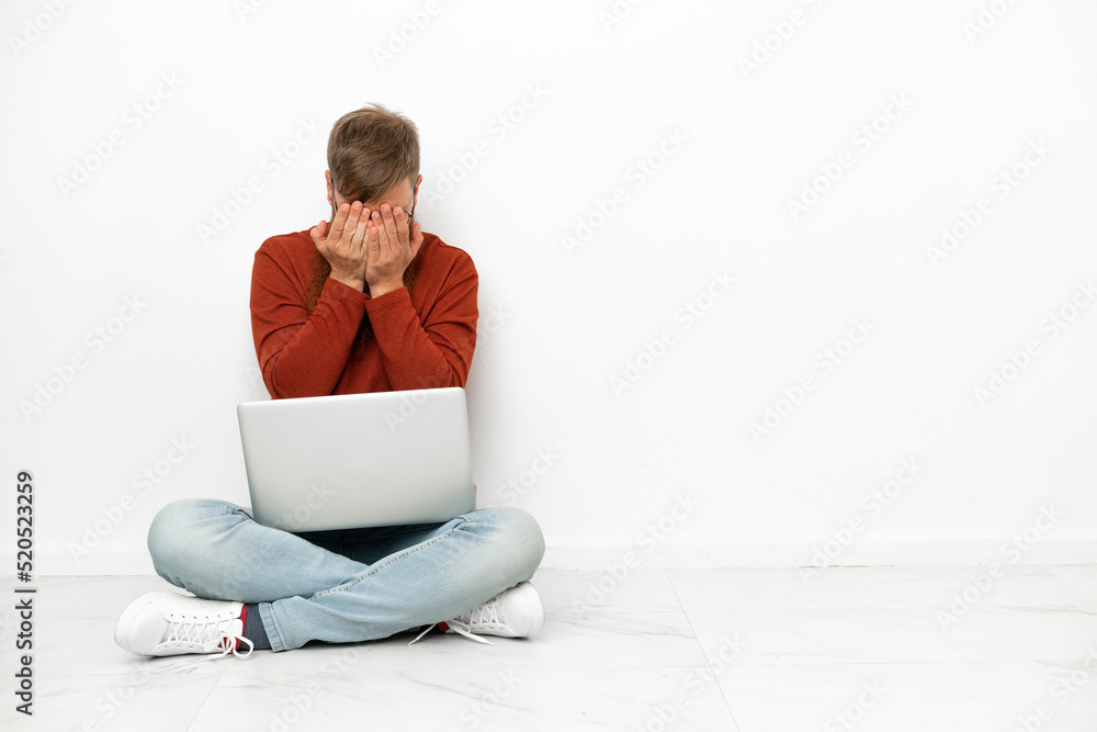 Young reddish caucasian man with laptop isolated on white background with tired and sick expression Young reddish caucasian man with laptop isolated on white background with tired and sick expression