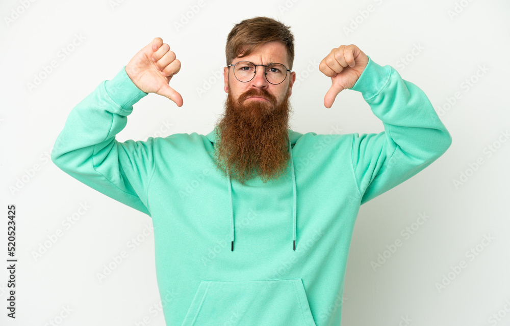 Young reddish caucasian man isolated on white background showing thumb down with two hands Young reddish caucasian man isolated on white background showing thumb down with two hands