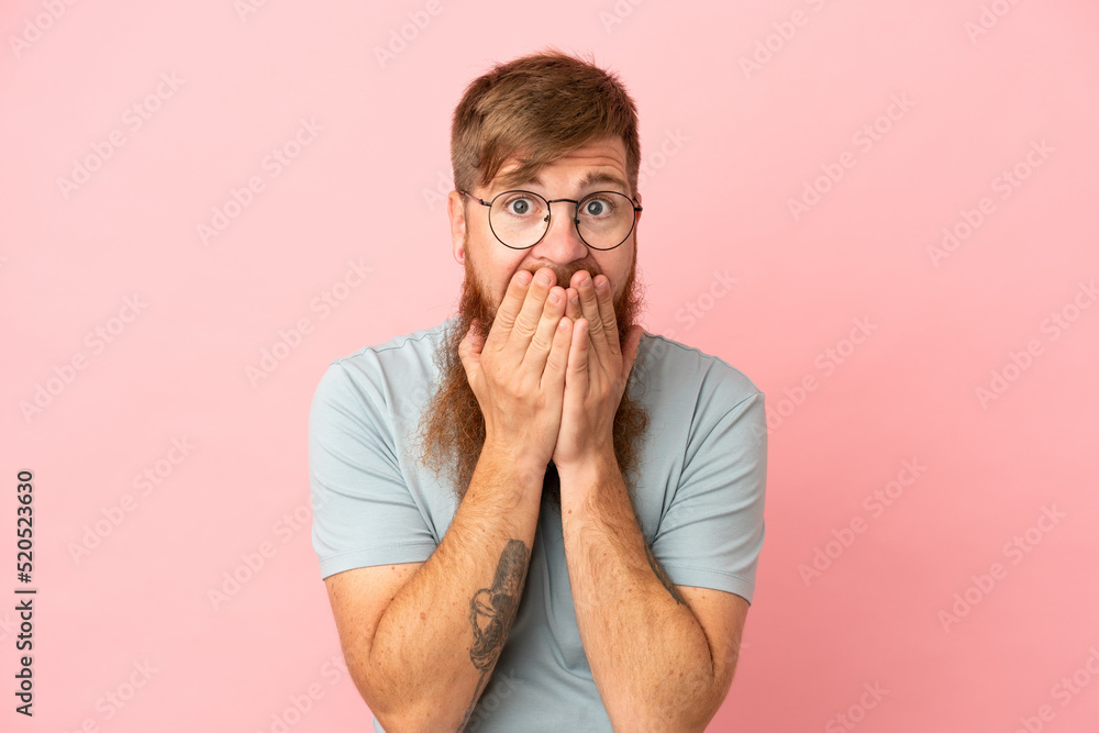 Young reddish caucasian man isolated on pink background happy and smiling covering mouth with hands Young reddish caucasian man isolated on pink background happy and smiling covering mouth with hands
