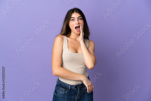 Young caucasian woman isolated on purple background with surprise and shocked facial expression © luismolinero