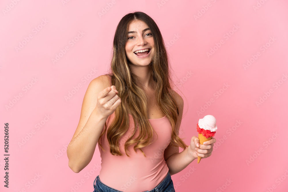 Young caucasian woman with a cornet ice cream isolated on pink background surprised and pointing front Young caucasian woman with a cornet ice cream isolated on pink background surprised and pointing front