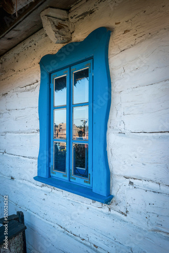 tradycyjne, rzeźbione i malowane na niebiesko drewniane okiennice w okolicach Białowieży