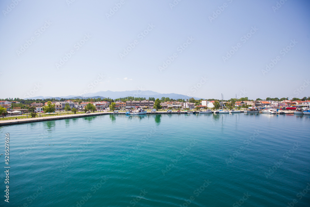 Panoramic view of Keramoti, small town, and port in Greece. Seascape. Beautiful blue water and sky. Summer day. Travel holiday vacation. 