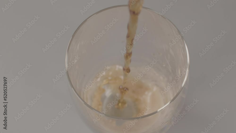High angle view of glass being filled with cola in slow motion High angle view of glass being filled with cola in slow motion