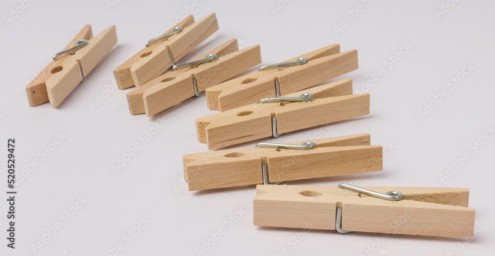 wooden clothespins lie in a corner on a white background with copy space