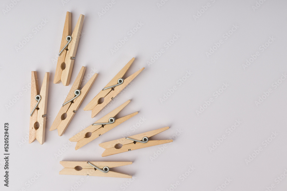 wooden clothespins lie in a corner on a white background with copy space