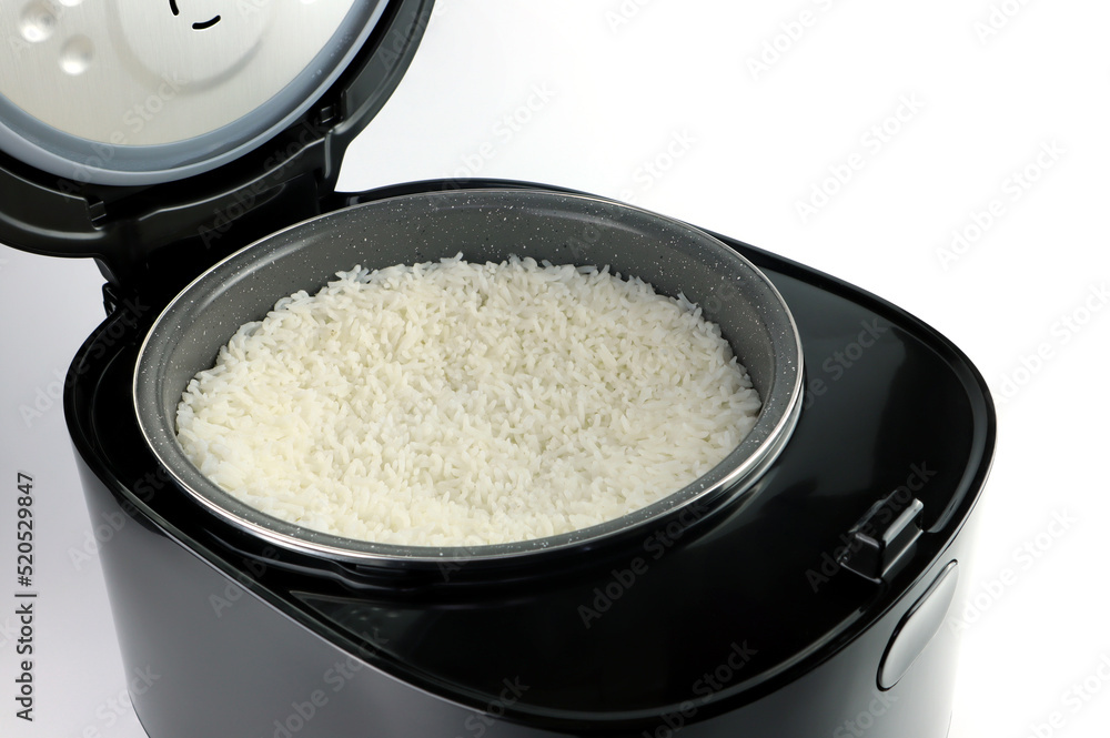 Thai jasmine rice is cooked in a modern design digital black rice cooker for breakfast and is put on the white table with in the white modern kitchen Thai jasmine rice is cooked in a modern design digital black rice cooker for breakfast and is put on the white table with in the white modern kitchen