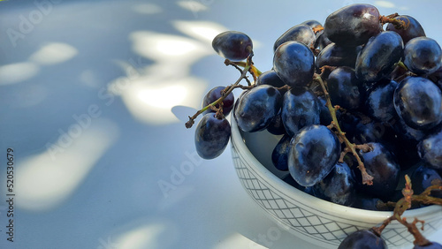 Purple grapes in bowl with stalk isolated on white background and shadow 01