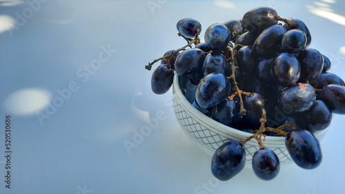 Purple grapes in bowl with stalk isolated on white background and shadow 02