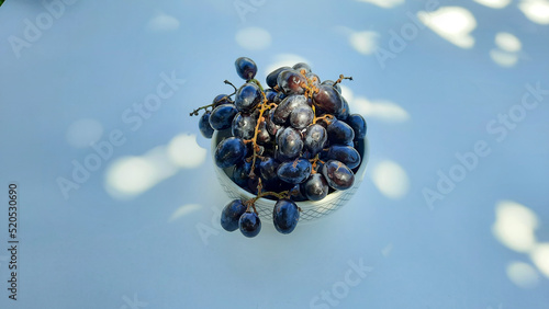 Purple grapes in bowl with stem in center isolated on white background and shadow 03