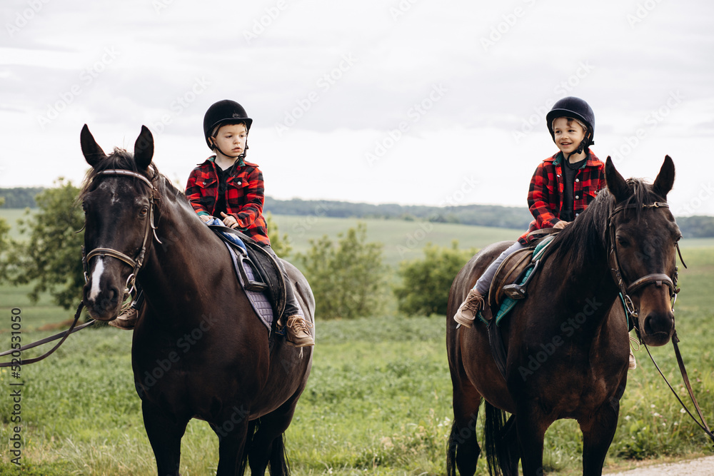 Two boys brothers riding horses Two boys brothers riding horses
