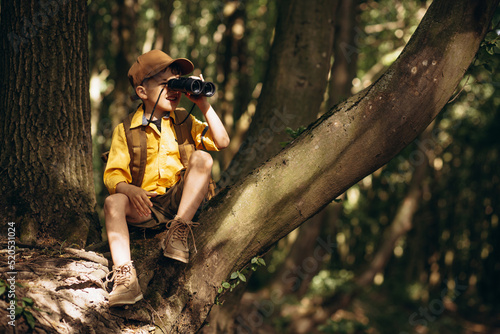 Boyscout travelling in the woods investigating nature photo