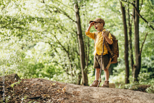 Photography Boy traveler walking in the forest with rucksuck and stick